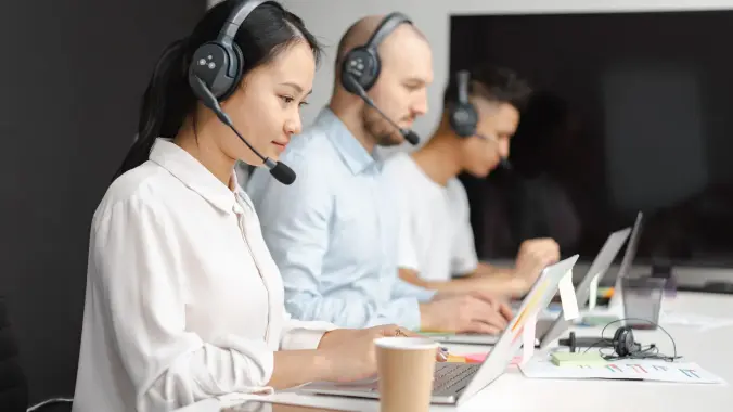 Conversational AI in customer service: contact center agents working with headsets